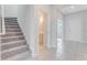 Welcoming entryway with staircase, tile flooring, and convenient powder room access at 1211 Normandy Dr, Haines City, FL 33844