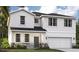 Charming two-story home with a modern design, stone accents, a two-car garage and well-manicured lawn at 1211 Normandy Dr, Haines City, FL 33844
