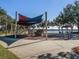Community playground with shade covers, climbing structures, and a lake view at 1211 Normandy Dr, Haines City, FL 33844