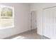 Bright spare bedroom with gray vinyl flooring, closet, and view from the window at 13 Oak Trail Pl, Ocala, FL 34472