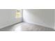 Empty bedroom showcasing light gray vinyl flooring and a window with a view at 13 Oak Trail Pl, Ocala, FL 34472