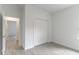Spare bedroom with light gray vinyl flooring, closet, and an open door to hallway at 13 Oak Trail Pl, Ocala, FL 34472
