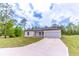 Attractive single-story home with a wide driveway leading to an attached two-car garage at 13 Oak Trail Pl, Ocala, FL 34472