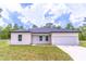 Inviting single-story home with a well-manicured lawn and an attached two-car garage at 13 Oak Trail Pl, Ocala, FL 34472