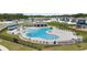 Inviting community pool featuring plenty of lounge chairs, palm trees, and adjacent playground at 1580 Eucalyptus Way, Davenport, FL 33837