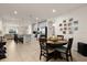 Open-concept dining area features tile floors, a stylish table and chairs, and a seamless transition into the kitchen at 1580 Eucalyptus Way, Davenport, FL 33837