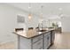 Granite kitchen island with stainless steel dishwasher and modern hanging lights at 1580 Eucalyptus Way, Davenport, FL 33837