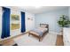 Bright bedroom with wood floors and a light blue accent wall provides a modern and relaxing living space at 1624 Malcolm Pointe Dr, Winter Garden, FL 34787