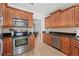 Well-equipped kitchen with stainless steel appliances, wood cabinets, and black granite countertops at 1624 Malcolm Pointe Dr, Winter Garden, FL 34787