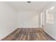 Minimalist living room with white paneling, hardwood floors, and open access to other areas of the home at 16336 Old Cheney Hwy, Orlando, FL 32833