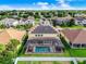 Aerial view of a home with a screened pool, solar panels, and well-kept landscaping in a suburban setting at 1802 Candlenut Cir, Apopka, FL 32712