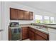 Chic bar area featuring dark wood cabinets, stylish countertops, built in wine fridge, and views from the window at 1802 Candlenut Cir, Apopka, FL 32712
