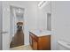 Clean bathroom with vanity and mirror, leading to a hallway and other rooms, optimizing space at 1802 Candlenut Cir, Apopka, FL 32712