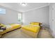 Bright bedroom featuring two twin beds with sunny yellow comforters and plenty of natural light at 1802 Candlenut Cir, Apopka, FL 32712
