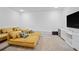 Cozy bonus room with plush carpet and a large yellow sectional sofa, great for relaxing and watching movies at 1802 Candlenut Cir, Apopka, FL 32712