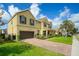 Charming two-story home with a brick driveway, manicured lawn and a two-car garage at 1802 Candlenut Cir, Apopka, FL 32712