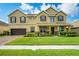 Well-maintained two-story home featuring a manicured lawn, shrubbery, and a two-car garage at 1802 Candlenut Cir, Apopka, FL 32712