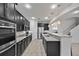Kitchen with stainless steel appliances, granite countertops, dark wood cabinetry, and staircase view at 1802 Candlenut Cir, Apopka, FL 32712
