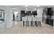 Open kitchen with stainless steel appliances, granite countertops, island seating, and dark wood cabinetry at 1802 Candlenut Cir, Apopka, FL 32712