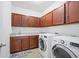 Well-equipped laundry room features wood cabinetry, granite countertop, and modern appliances at 1802 Candlenut Cir, Apopka, FL 32712