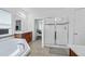 Bright, modern bathroom with separate shower and tub, complemented by classic wood vanity and large mirror at 1802 Candlenut Cir, Apopka, FL 32712