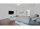 Spacious main bedroom featuring sleek hardwood floors and a comfortable king-size bed for a luxurious retreat at 1802 Candlenut Cir, Apopka, FL 32712