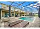 Backyard with a large screened-in pool, an umbrella and lounge chairs at 1802 Candlenut Cir, Apopka, FL 32712