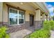 Inviting front porch with stone accents, a classic wooden door, and lush greenery at 1802 Candlenut Cir, Apopka, FL 32712