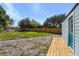 Large backyard area with a wooden deck and blue shed conversion on the right at 1900 E Orange Ave, Eustis, FL 32726