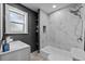 Bathroom features a tub and shower with marble tile and modern fixtures at 1900 E Orange Ave, Eustis, FL 32726