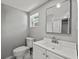 Bright bathroom with vanity and toilet, plus large mirror and view of the shower at 1900 E Orange Ave, Eustis, FL 32726