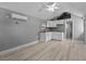 Open living area with kitchenette, wood floors and modern finishes and access to bathroom at 1900 E Orange Ave, Eustis, FL 32726