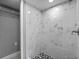 Tiled shower with rainfall shower head and black and white mosaic floor at 1900 E Orange Ave, Eustis, FL 32726