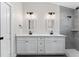 Bathroom featuring a double vanity with white cabinets, matte black hardware, and gray tiled shower at 2132 Pine Meadows Golf Course Rd, Eustis, FL 32726
