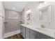 Bathroom with a double vanity, gray cabinets, quartz countertops and walk-in tiled shower at 2132 Pine Meadows Golf Course Rd, Eustis, FL 32726