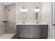 Bathroom with double sink vanity, gray cabinets, quartz counters and tiled shower at 2132 Pine Meadows Golf Course Rd, Eustis, FL 32726