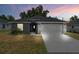 Charming single-story home with a well-manicured lawn and a two-car garage at dusk at 2132 Pine Meadows Golf Course Rd, Eustis, FL 32726