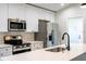 Modern kitchen with white cabinets, stainless steel appliances, and quartz countertops at 2132 Pine Meadows Golf Course Rd, Eustis, FL 32726
