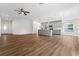 Open-concept living space with wood flooring, a ceiling fan, and a modern kitchen with gray cabinets at 2132 Pine Meadows Golf Course Rd, Eustis, FL 32726