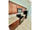Kitchen view with granite countertops, dark wood cabinets, and black appliances at 238 Riverbend Dr # 105, Altamonte Springs, FL 32714