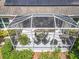 Aerial view of a screened lanai, surrounded by lush greenery, offering a private outdoor retreat at 2409 Twickingham Ct, Clermont, FL 34711