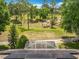 A backyard view showcasing solar panels and a screened enclosure with a golf course view in the distance at 2409 Twickingham Ct, Clermont, FL 34711