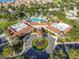 Aerial view of the clubhouse amenities, showcasing an inviting entrance, lush greenery, and convenient parking at 2409 Twickingham Ct, Clermont, FL 34711