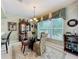 Formal dining room with glass table, upholstered chairs, and decorative chandelier at 2409 Twickingham Ct, Clermont, FL 34711
