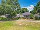 Charming single-story home with a screened lanai, lush landscaping, and solar panels, nestled on a well-manicured lawn at 2409 Twickingham Ct, Clermont, FL 34711
