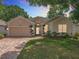 Charming one-story home with a brick driveway and manicured lawn at 2409 Twickingham Ct, Clermont, FL 34711