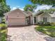 Charming home with a brick driveway and meticulously maintained lawn at 2409 Twickingham Ct, Clermont, FL 34711
