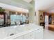 Kitchen view featuring white countertops and sink overlooking breakfast area with chandelier and large window at 2409 Twickingham Ct, Clermont, FL 34711