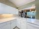 Bright kitchen with a white countertop sink overlooking the breakfast area, and cabinets with gold handles at 2409 Twickingham Ct, Clermont, FL 34711