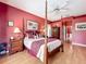Spacious main bedroom featuring a four-poster bed, red walls, and hardwood floors at 2409 Twickingham Ct, Clermont, FL 34711